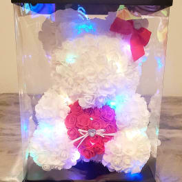 White and pink rose teddy bear in a clear display box with a bow