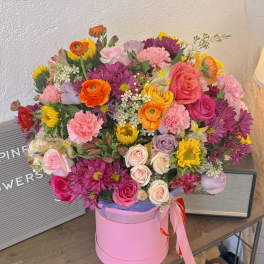 Mixed bouquet in a pink hat box with roses and daisies