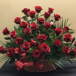 Basket arrangement of red roses with a red ribbon