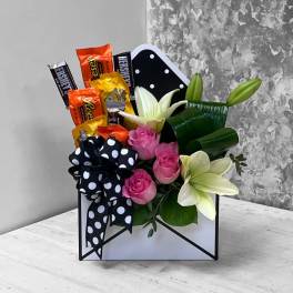 Candy bouquet with pink roses and white lilies in a black-and-white polka dot box