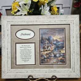 Framed memorial display with yellow and white flowers behind it