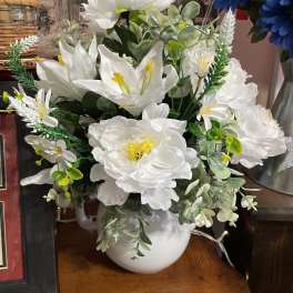 White floral arrangement in a white pitcher vase
