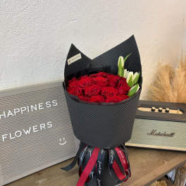 Red roses and white lilies in a black wrapped bouquet