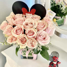 Pink roses in a square glass vase with Mickey ears topper