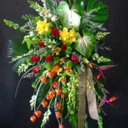 Tall tropical floral standing spray with red, yellow, and orange blooms