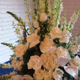 Tall white floral arrangement with roses, orchids, and lilies