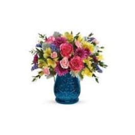 Colorful mixed bouquet in a blue glass vase