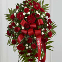 Red floral standing spray with a red ribbon on an easel