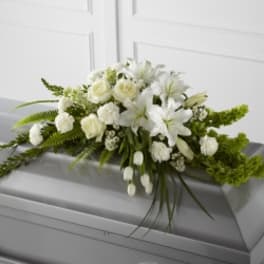 White floral casket spray with lilies and roses
