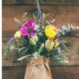 Bouquet of colorful flowers in a brown paper wrap tied with twine
