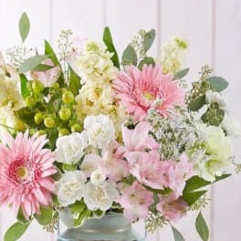 Pink gerbera daisies and white flowers in a vase