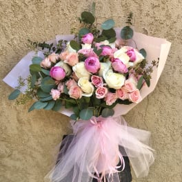 Bouquet of pink and white roses with eucalyptus and a pink tulle bow