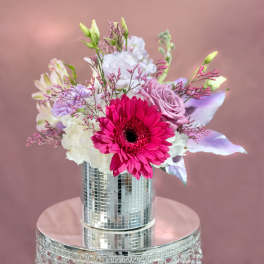 Pink and white bouquet in a mirrored vase on a reflective stand