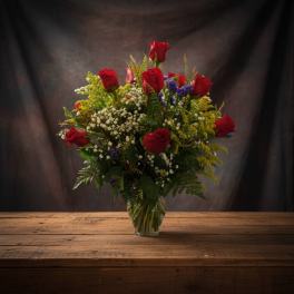 Red roses arranged in a clear glass vase