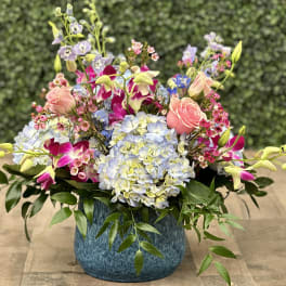 Colorful mixed flower arrangement in a blue vase