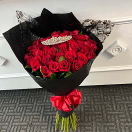 Bouquet of red roses wrapped in black paper with a red ribbon