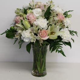 Pink roses and white lilies in a clear glass vase