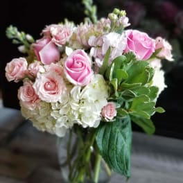 Pink roses and white hydrangeas in a clear glass vase