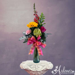 Tall mixed bouquet in a blue glass vase with a pink plaid ribbon