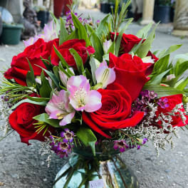 Red roses and pink alstroemeria in a glass vase