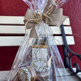 Gift basket with wrapped candles tied in a burlap bow