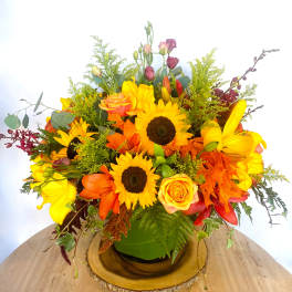 Bright mixed bouquet with sunflowers, roses, and lilies in a green vase