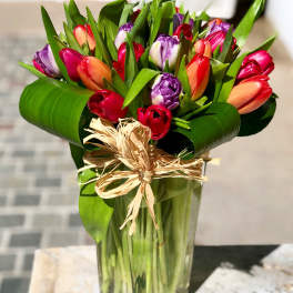 Bouquet of multicolored tulips in a clear glass vase