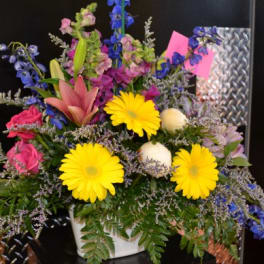 Colorful mixed flower arrangement in a white container