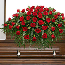 Red rose spray on a wooden casket