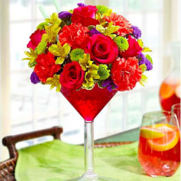 Bright mixed bouquet in a tall red martini glass vase