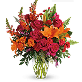 Bouquet of pink roses and orange lilies in a clear glass vase