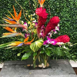 Tropical flower arrangement with bird of paradise and red blooms in a vase