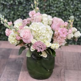 Pink and white bouquet in a dark green vase
