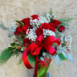 Red roses with baby's breath in a glass vase and red ribbon