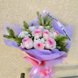 Pink roses in lavender wrap with a birthday ribbon
