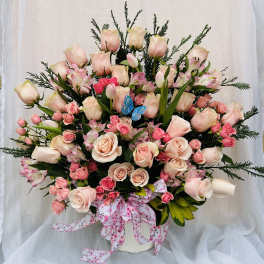 Large bouquet of pale pink roses and pink alstroemeria in a white vase