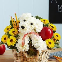 Basket arrangement with a white dog-shaped floral design and yellow daisies