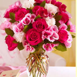 Pink and white rose bouquet in a clear glass vase