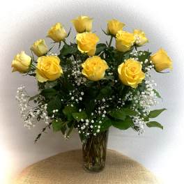 Yellow roses in a clear glass vase with white baby's breath