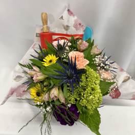 Mixed bouquet with pink, yellow, green, and purple flowers wrapped in floral paper