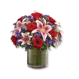 Bouquet of red roses and pink lilies in a glass vase