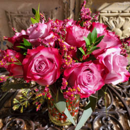 Pink and white roses arranged in a glass vase