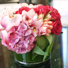 Pink and red floral arrangement in a glass vase