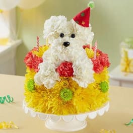 White teddy bear on a colorful flower-covered cake stand
