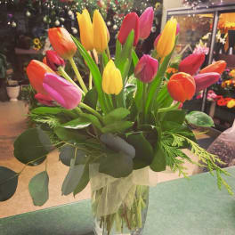 Bouquet of multicolored tulips in a clear glass vase