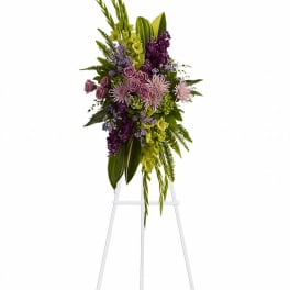 Tall floral spray with purple, pink, and green flowers on a stand