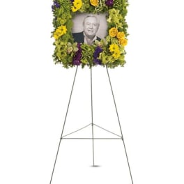 Standing floral tribute frame with a portrait photo in the center