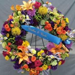 Colorful floral wreath with a blue ribbon reading Brother & Uncle