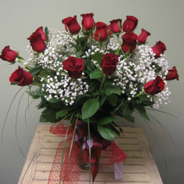 Bouquet of red roses with white baby's breath in a glass vase