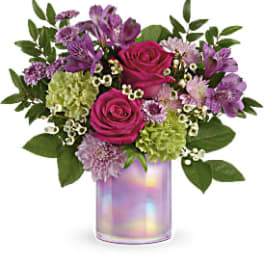 Bouquet of pink roses, purple alstroemeria, and green hydrangeas in a iridescent vase